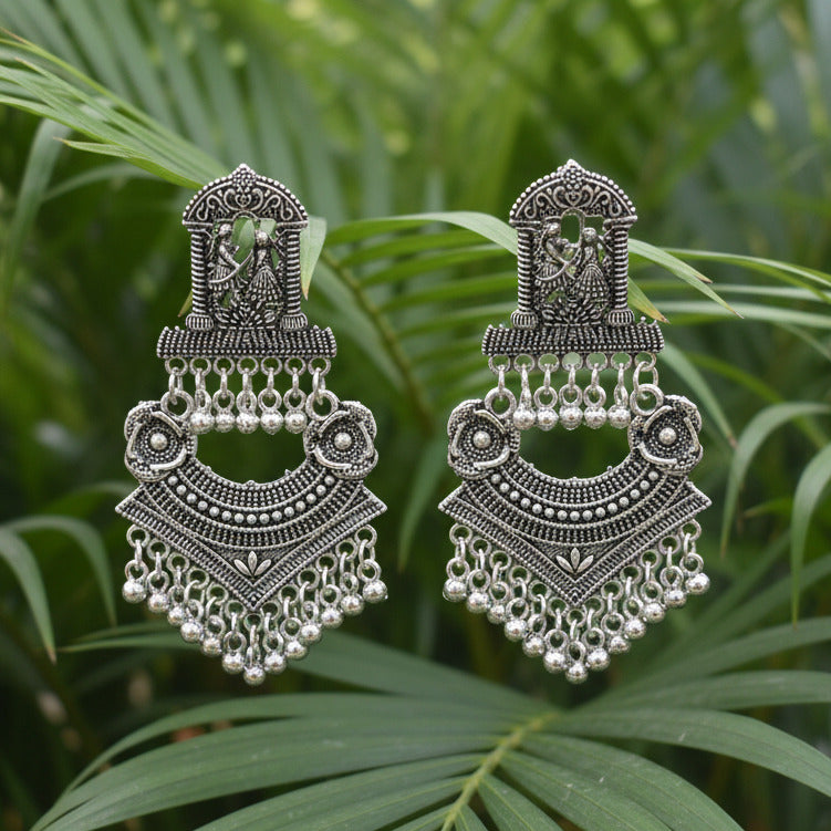 Pair of ornate silver earrings on a light gray background