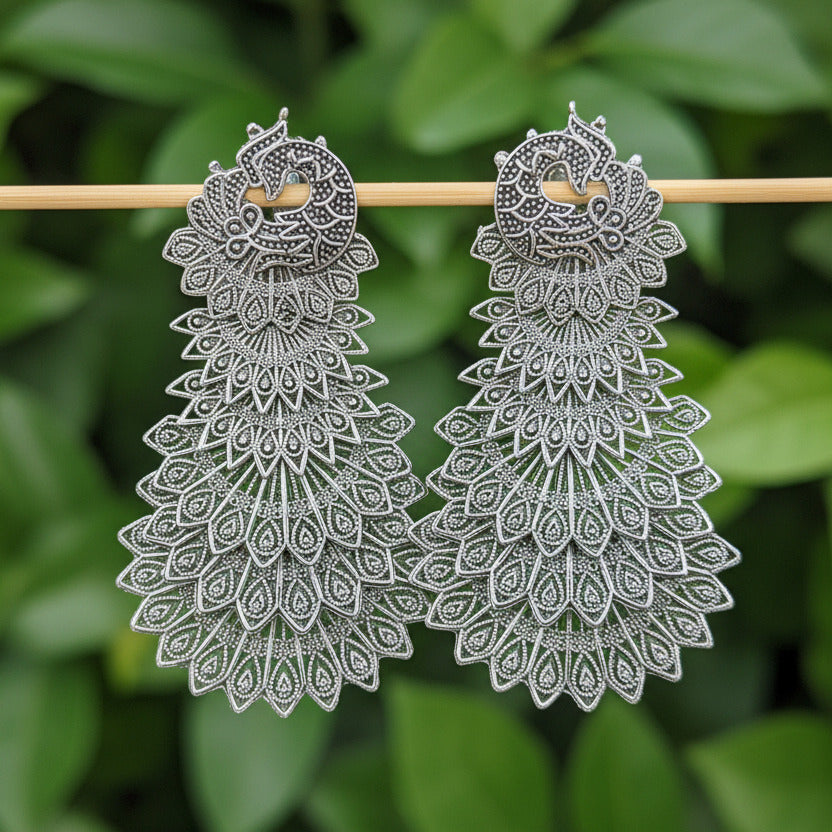 Pair of silver floral earrings on a black background