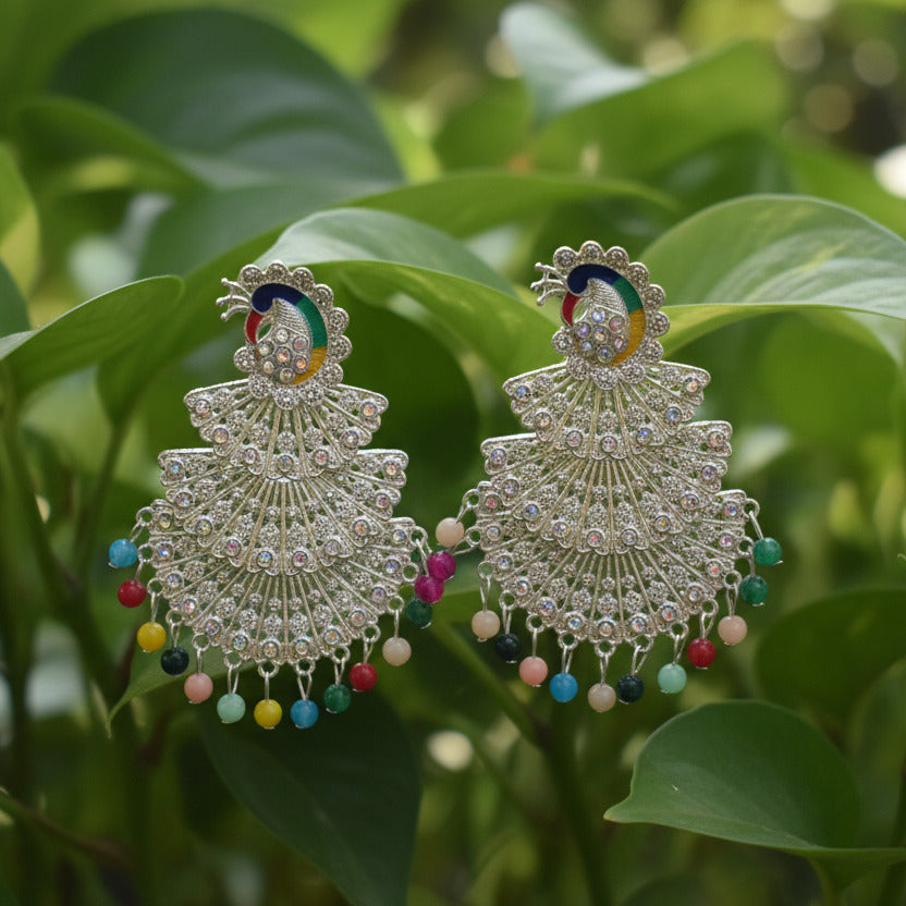 Pair of silver earrings with colorful beads on a gray background