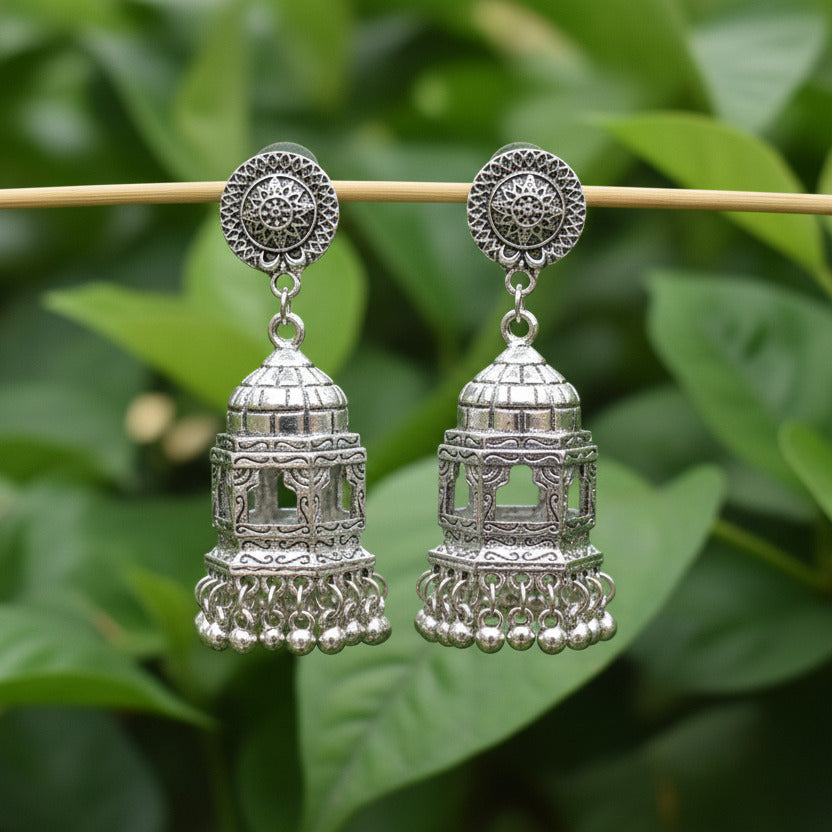 Decorative silver earrings on a gray background