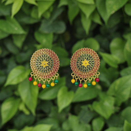 Pair of decorative earrings with gold, red, and green beads on a white background