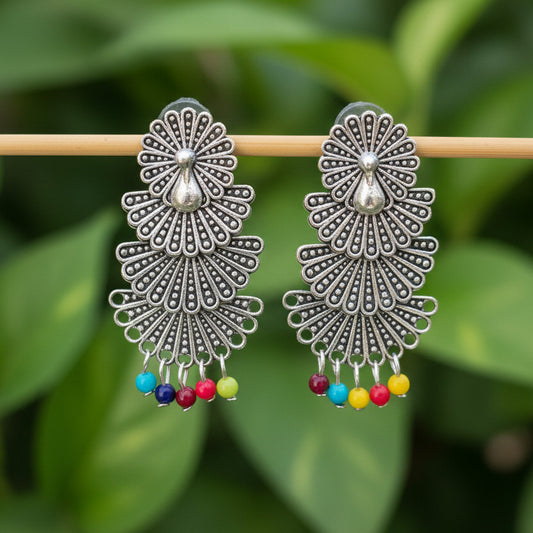 Decorative earrings with colorful beads on a dark textured background