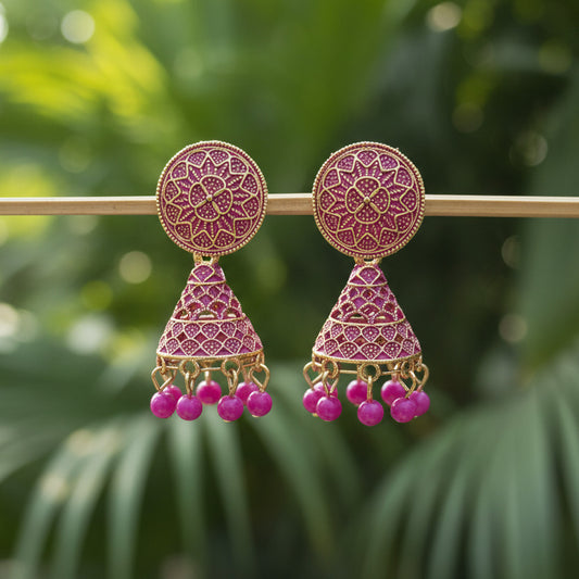 Ornate earrings with pink beads on a gray background