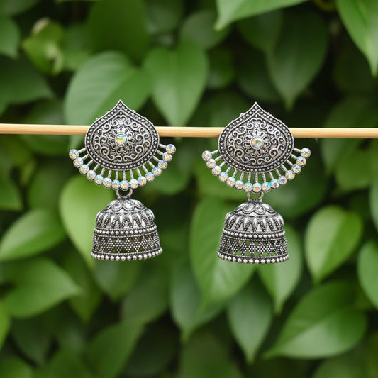 Pair of silver earrings on a stick against a dark background