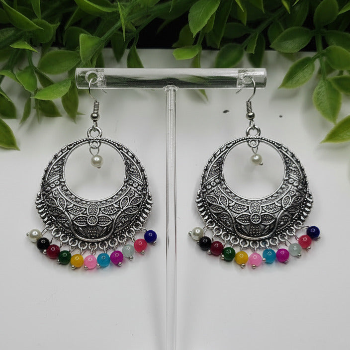 Pair of silver hoop earrings with colorful beads on a white background