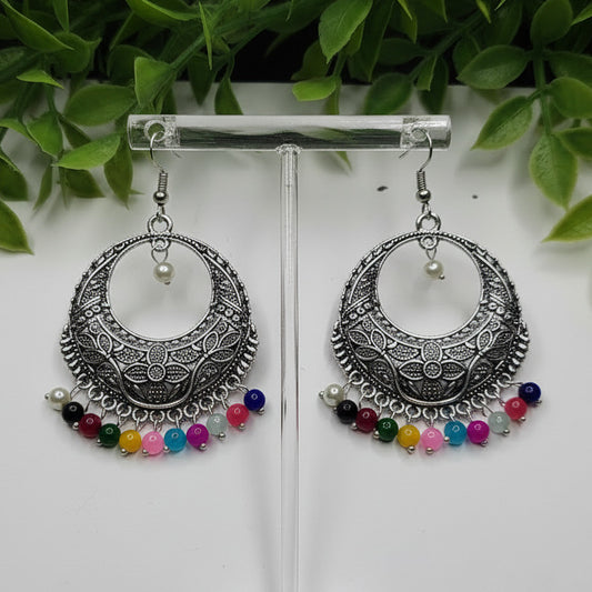 Pair of silver hoop earrings with colorful beads on a white background