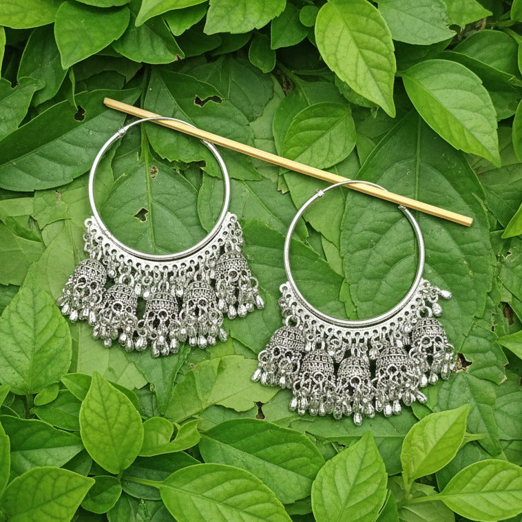 Pair of silver hoop earrings with intricate designs on a gray background