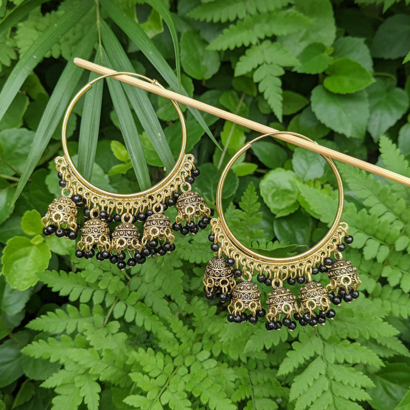 Gold hoop earrings with intricate designs on a gray background