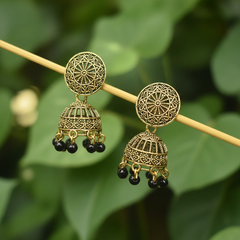 Gold earrings with intricate designs on a gray background