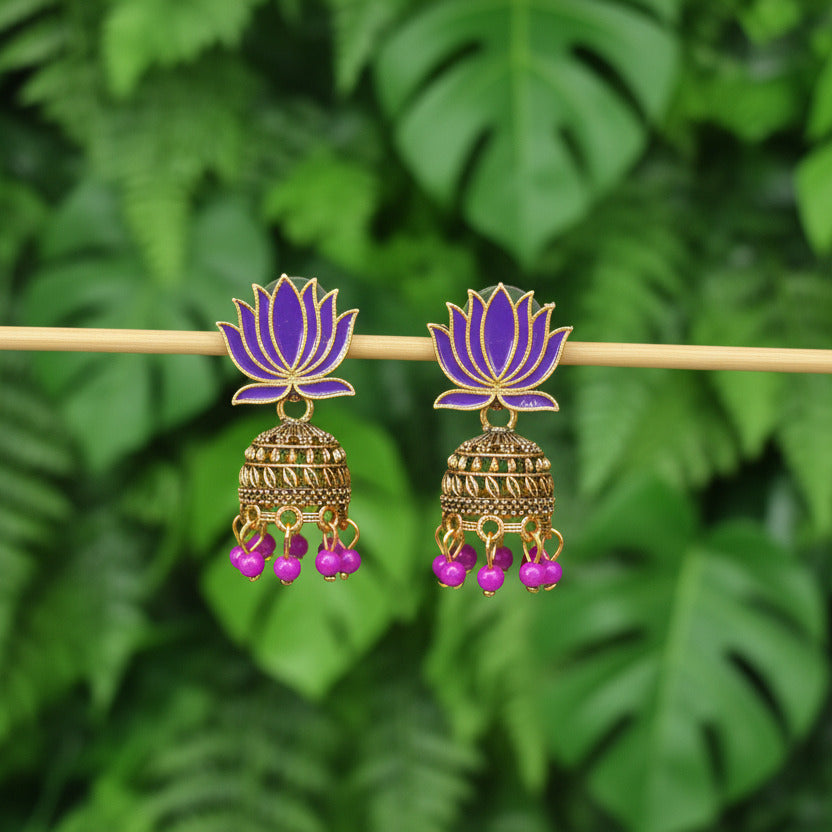 Pair of gold and purple earrings on a dark gray background
