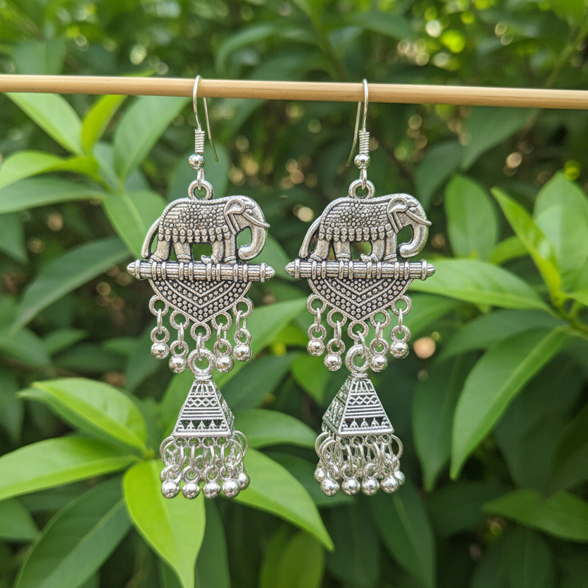 Pair of silver earrings on a dark fabric background