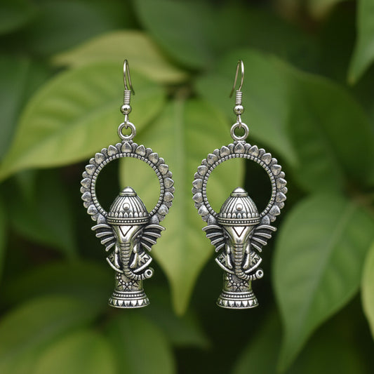 Pair of silver fish-shaped earrings on a gray background