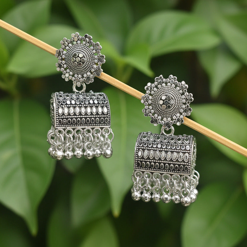 Pair of silver earrings on a dark fabric background