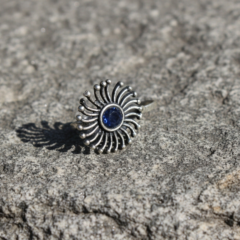 Silver sun-shaped pendant on a white background