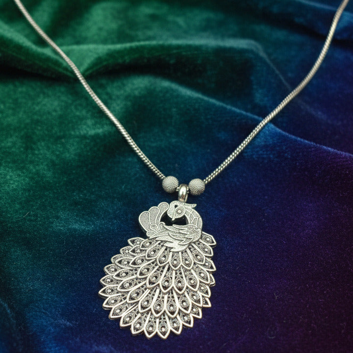 Silver necklace with a decorative pendant on a dark surface