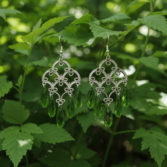 Pair of green leaf-shaped earrings on a light gray background