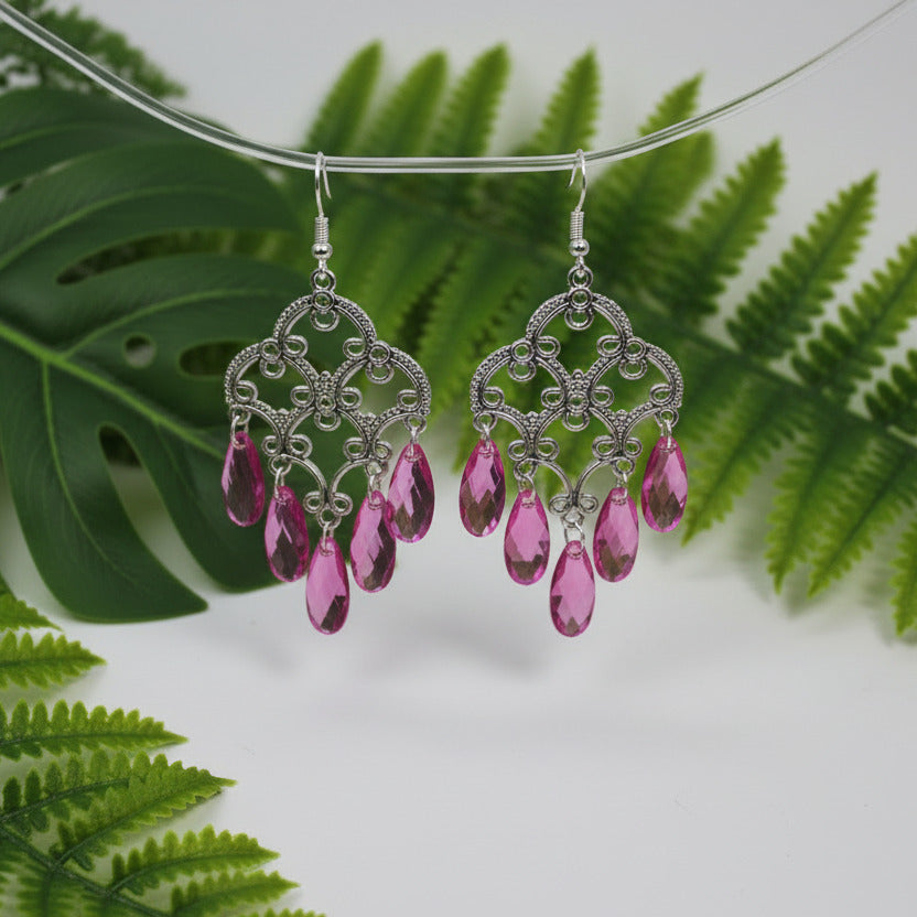 Pair of silver earrings with pink gemstones on a white background