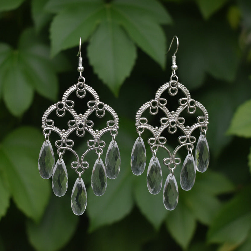 Pair of silver earrings with clear stones on a light gray background