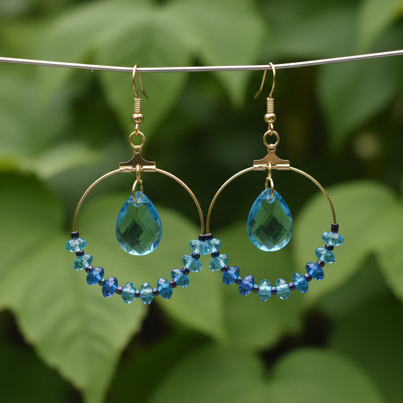 Pair of blue beaded earrings on a light gray background