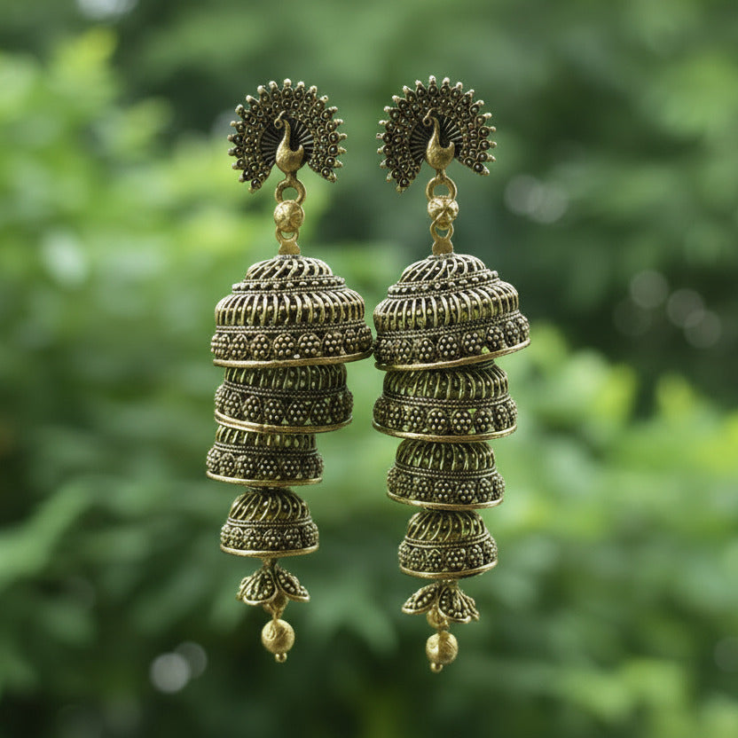 Gold earrings on a card held by a hand with a blurred background