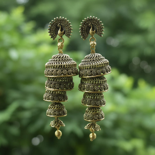 Gold earrings on a card held by a hand with a blurred background