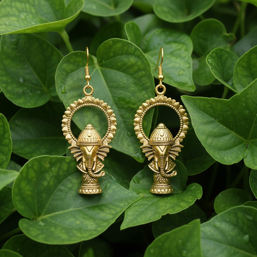 Pair of gold earrings on a dark fabric background