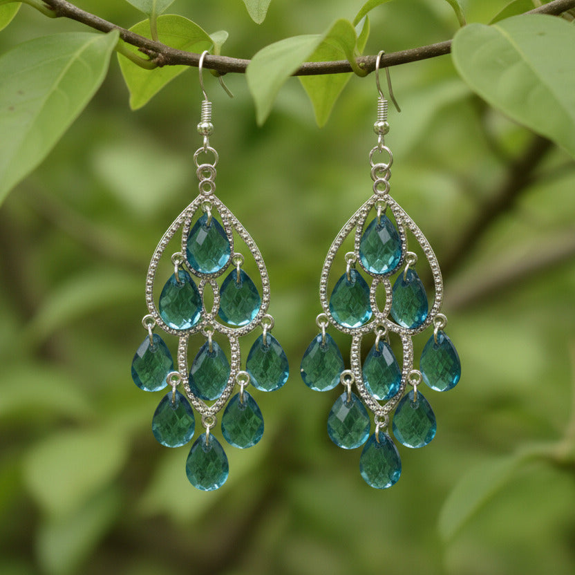 Pair of blue teardrop earrings with silver detailing on a light gray background